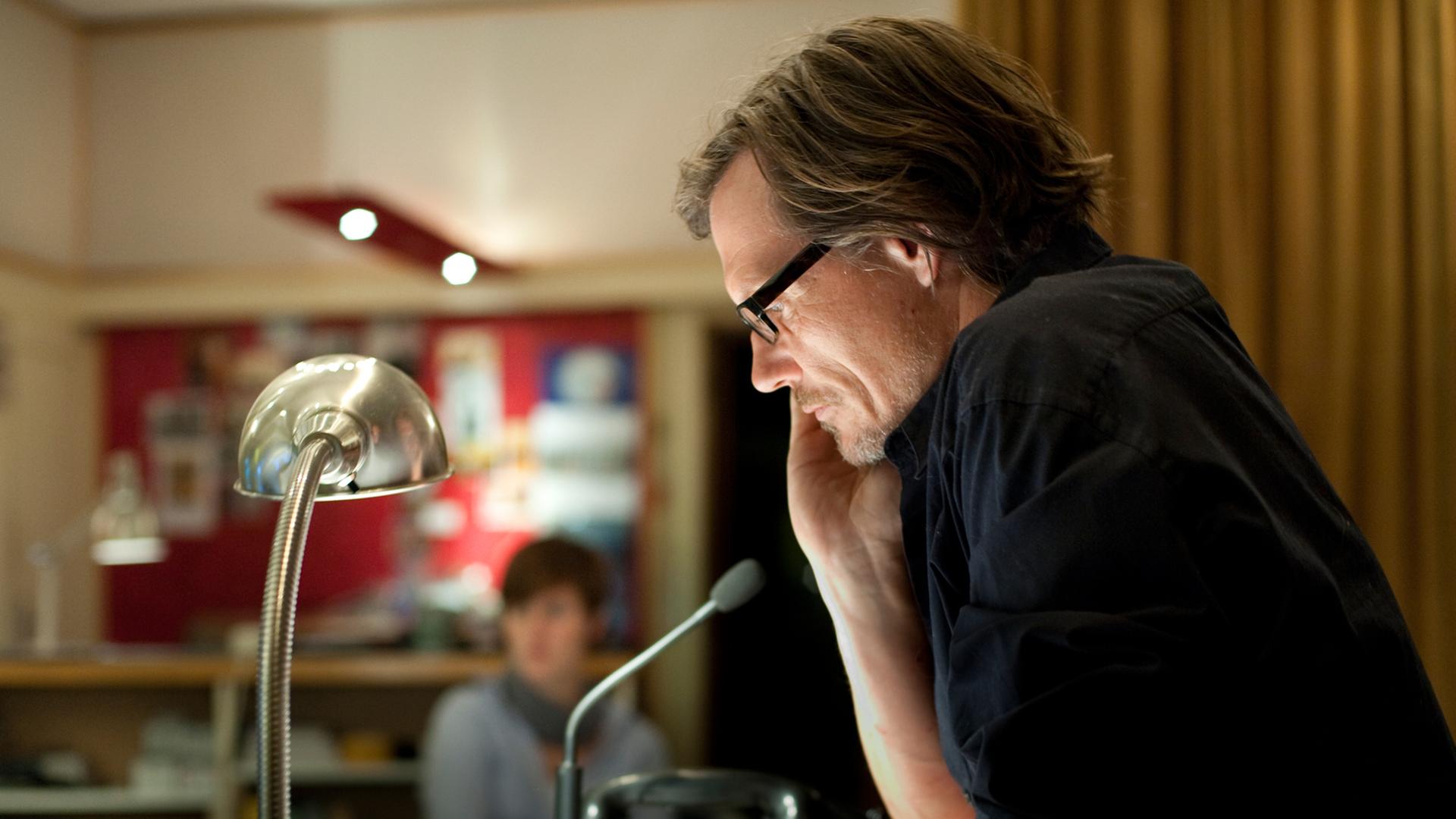 Alexander Schuhmacher bei der Regie im Studio, im Profil, die Hand am Kinn